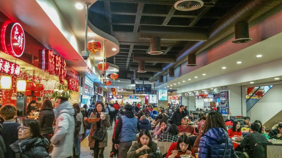 Food Court in New World Mall, Chinatown, Flushing, NYC decorated in bright red colors and lanterns.