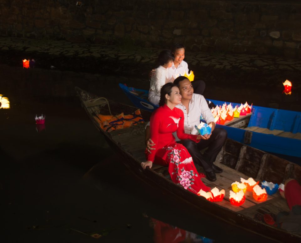 Couples go around in boats holding lights in Hoi An