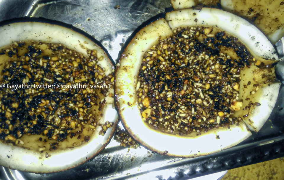 Sesame, rice, jaggery in the cut open fire-roasted coconut
